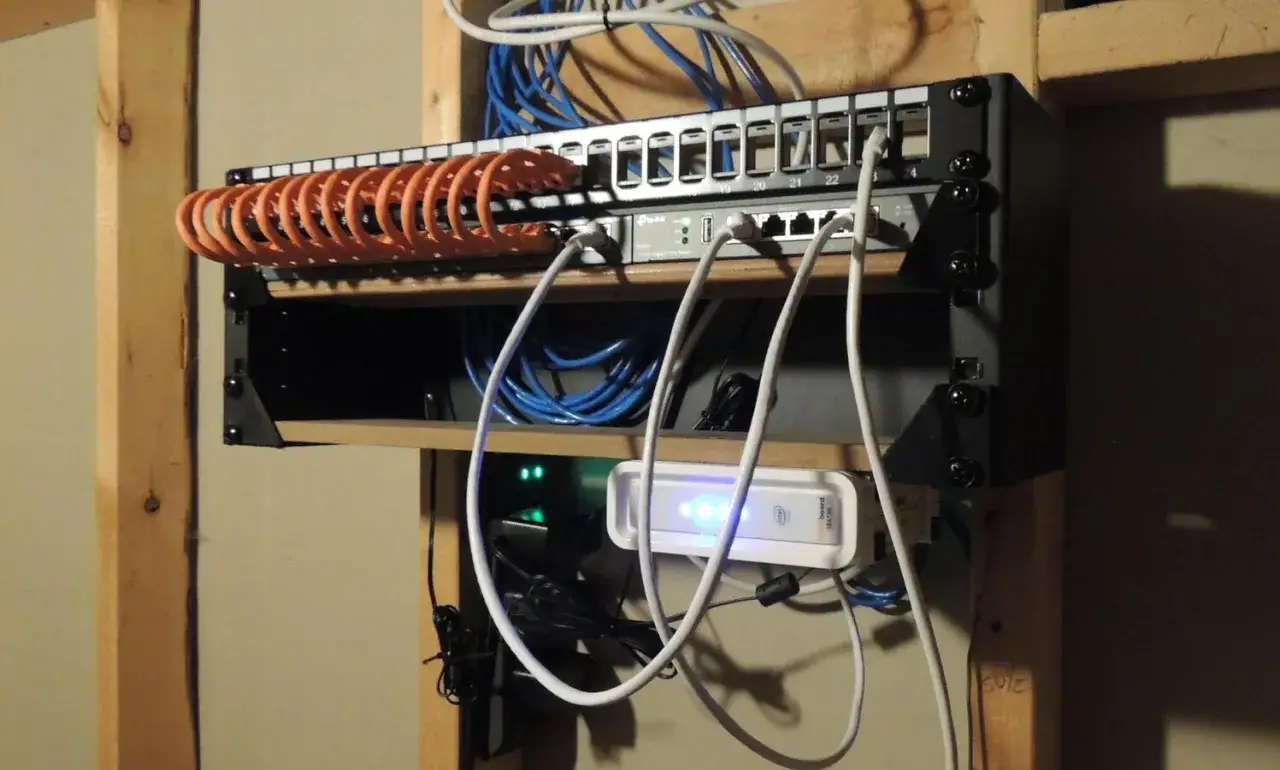 N&auml;tverkskabel 10 meter organiserad i en rackmonterad panel med switchar och en Intel NUC.
