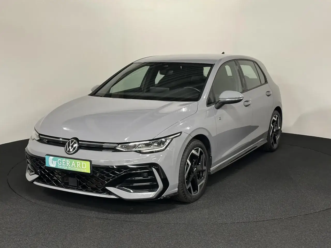 Une Volkswagen Golf 8 grise, avec sa longueur distinctive, est présentée sur un plateau tournant.