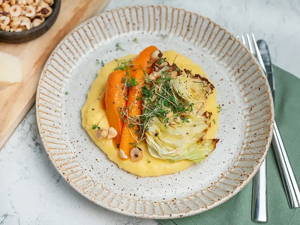 En kr&auml;mig italiensk polenta toppas med rostade mor&ouml;tter, k&aring;l och n&ouml;tter. En vacker och smakrik r&auml;tt.