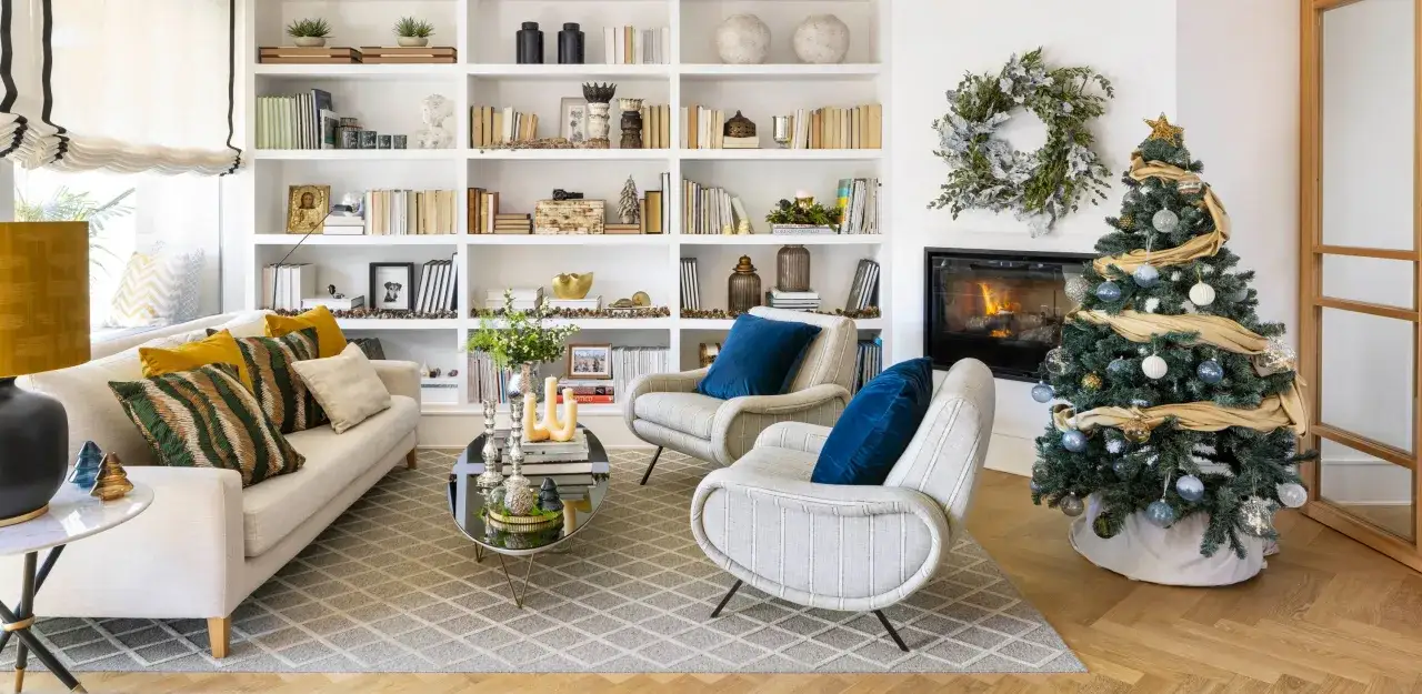 La casa de Navidad de el mueble: un árbol decorado, chimenea encendida y estanterías llenas de libros y adornos festivos crean un ambiente acogedor.