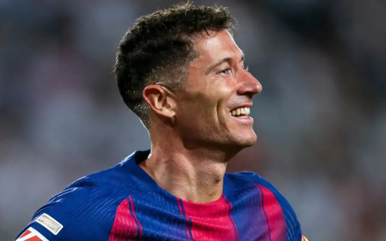 Uśmiechnięty Robert Lewandowski w koszulce FC Barcelony. To właśnie w tym klubie gra Lewandowski.