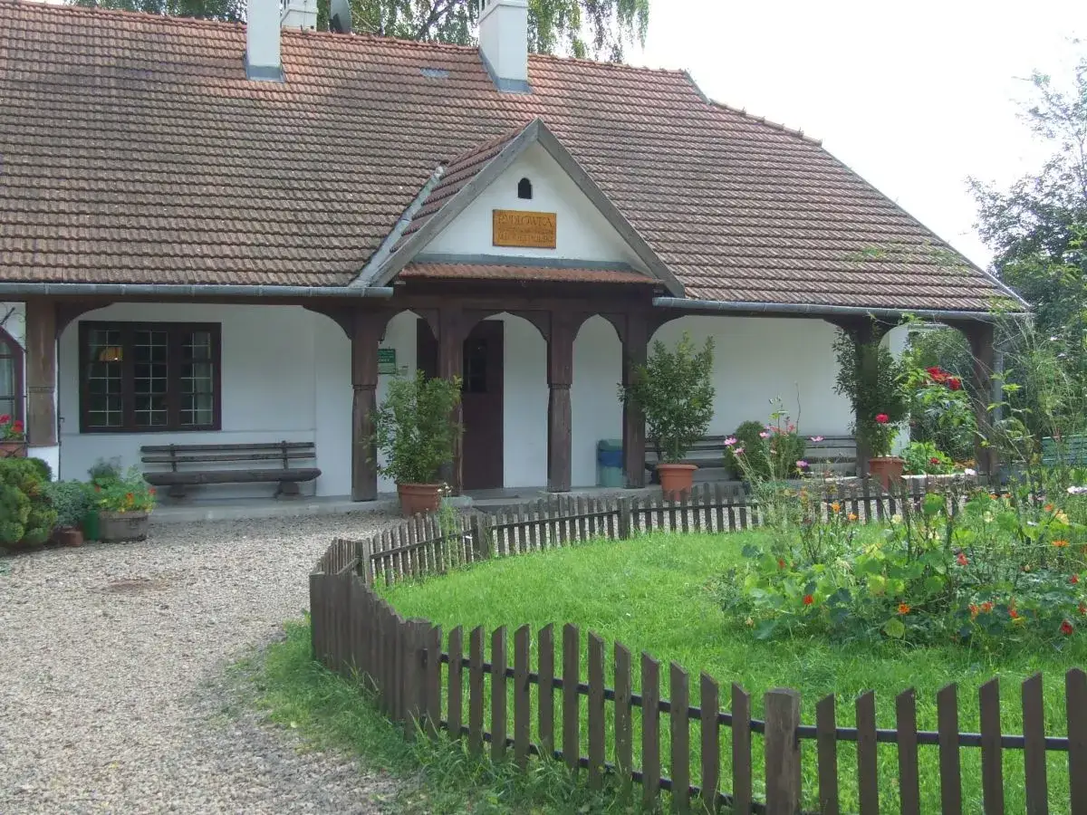 Urokliwy domek w Bronowicach Małych z werandą, ławką i kwitnącym ogrodem.