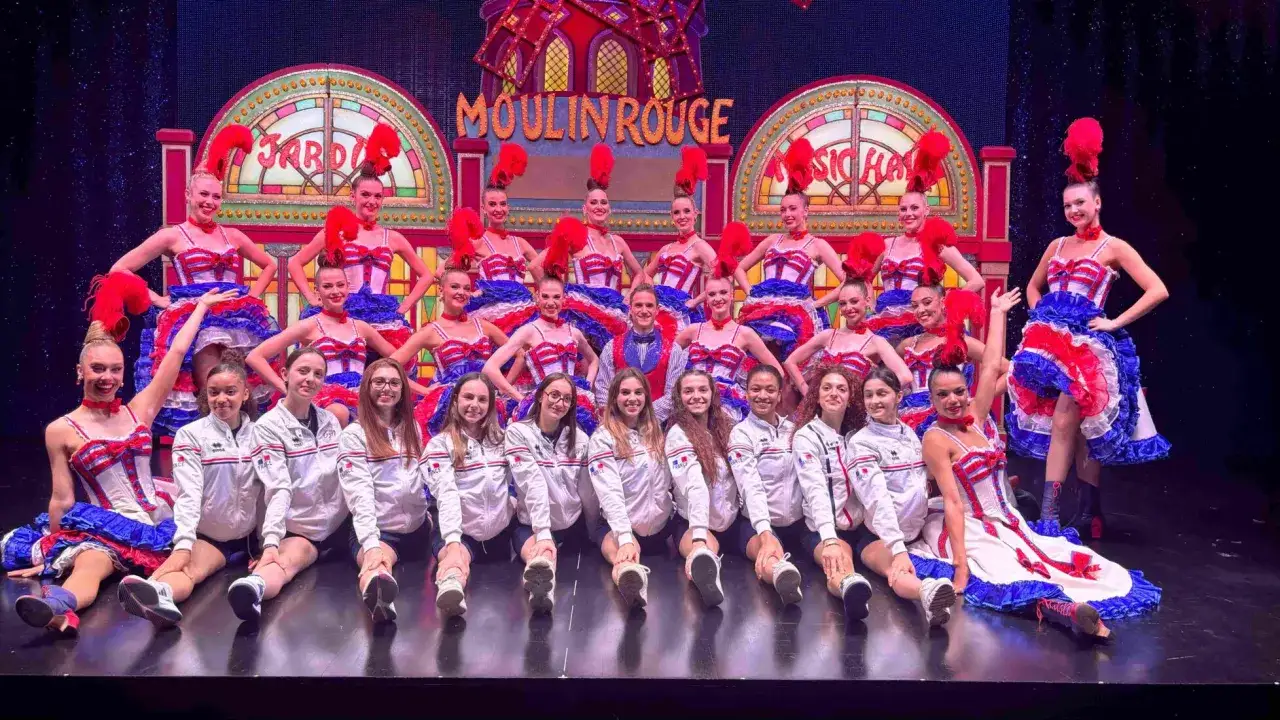 Groupe de danseuses en costumes du Moulin Rouge, prêtes pour un spectacle dont la durée promet d'être mémorable.