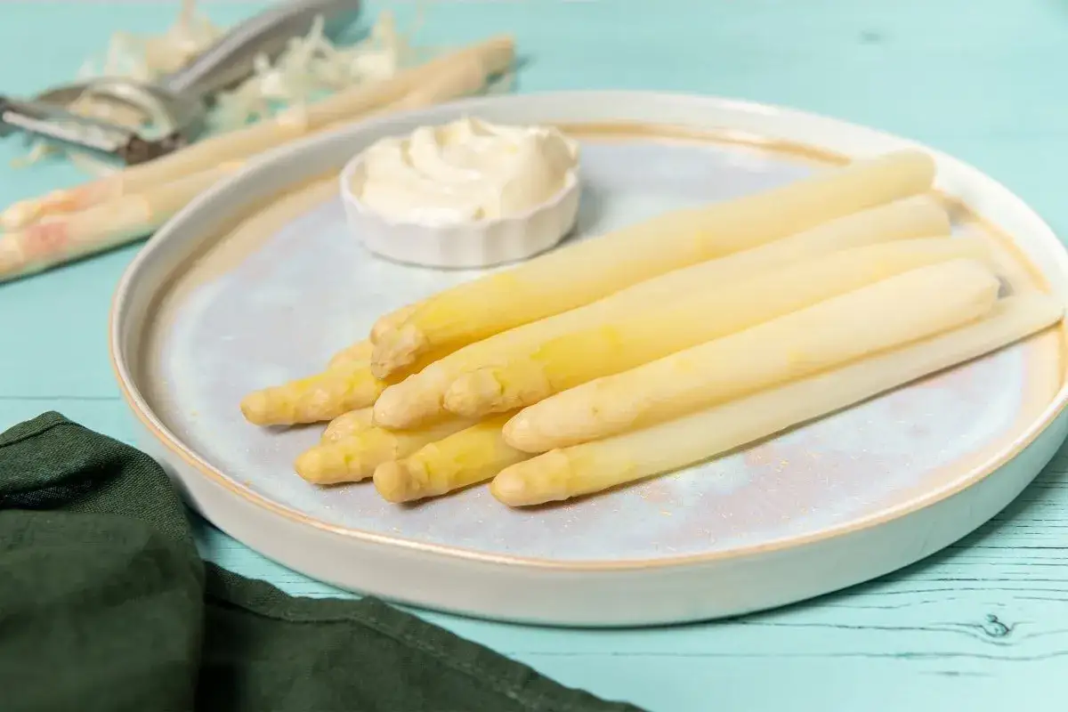 Espárragos blancos recién pelados, listos para disfrutar con una cremosa salsa. Un manjar de temporada.