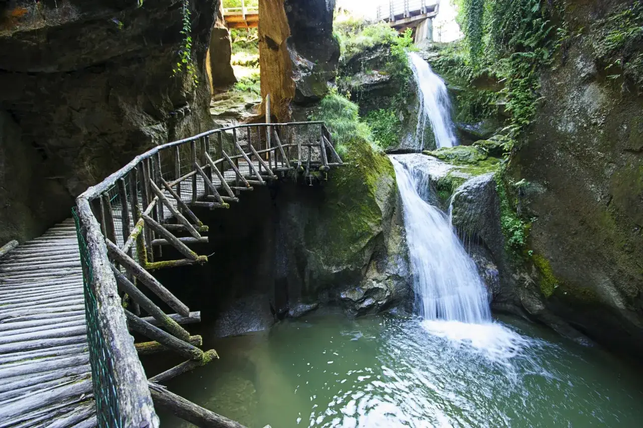 Sentiero in legno tra cascate e grotte in Veneto, un'oasi naturale incantevole.