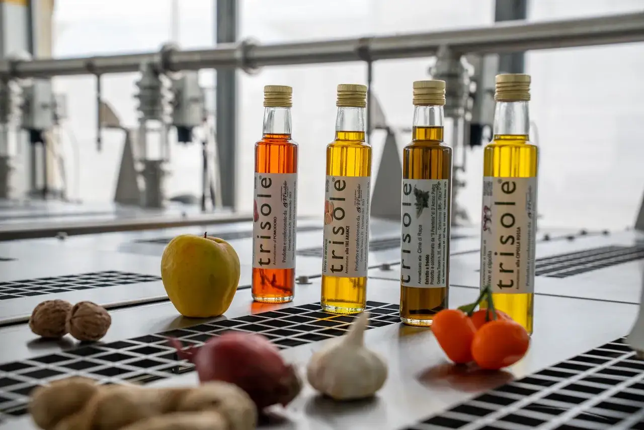 Bottiglie di olio d'oliva aromatizzato, con ingredienti come pomodoro, arancia, cime di rapa e cipolla. La differenza tra olio di oliva e olio extravergine &egrave; fondamentale per la qualit&agrave;.