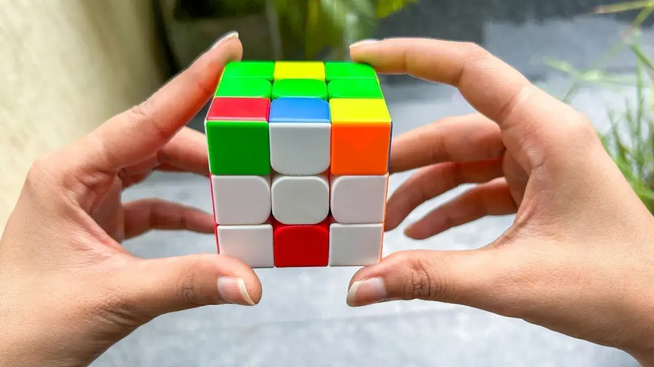 H&auml;nder h&aring;ller en Rubiks kub, redo f&ouml;r speedcubing.