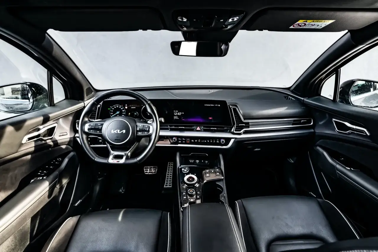 Wnętrze Kia Sportage GT Line: skórzana tapicerka, nowoczesny kokpit z dużym ekranem i cyfrowymi zegarami.