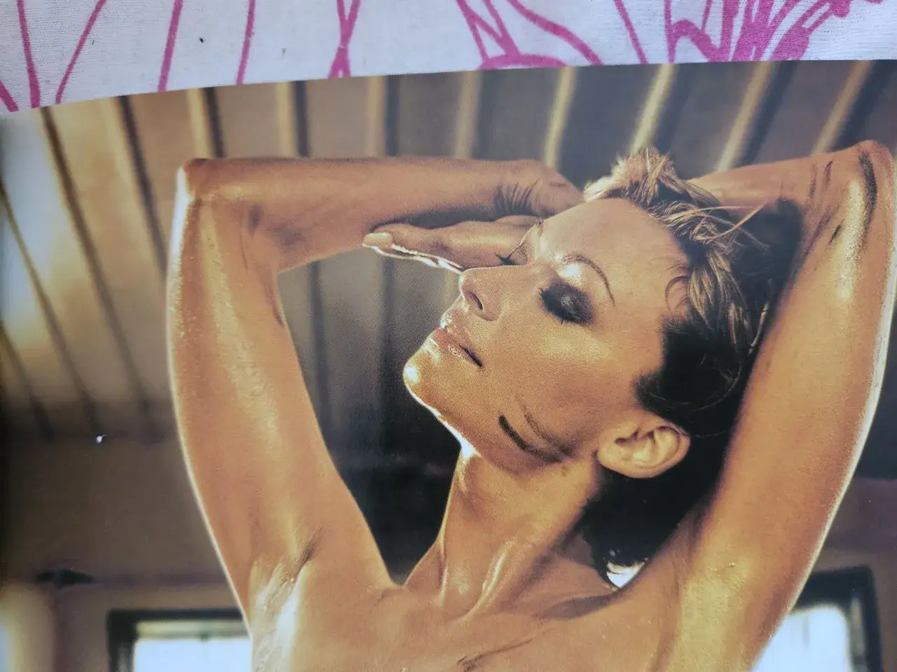 Martyna Wojciechowska w zmysłowej sesji dla magazynu Playboy, z dłońmi uniesionymi ku twarzy.