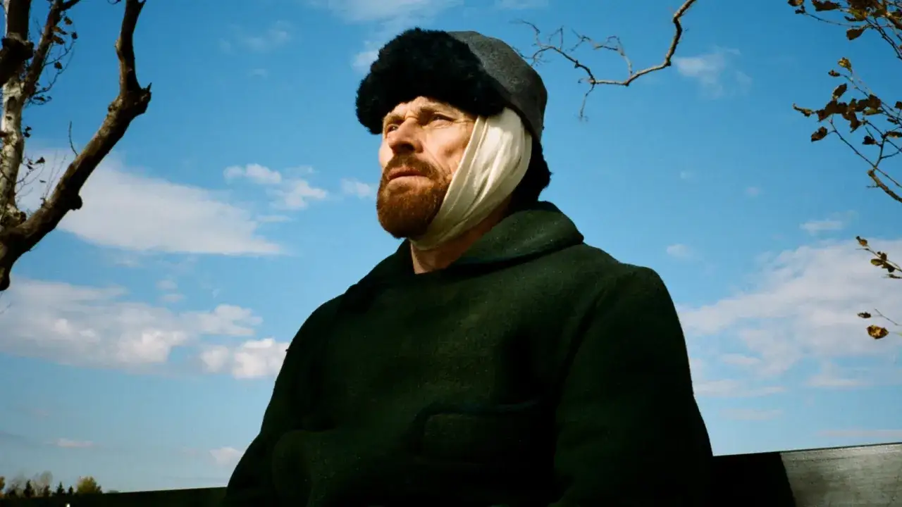 W filmie o Van Goghu Willem Dafoe jako malarz z zabandażowanym uchem, w czapce i ciemnym płaszczu, patrzy w niebo.