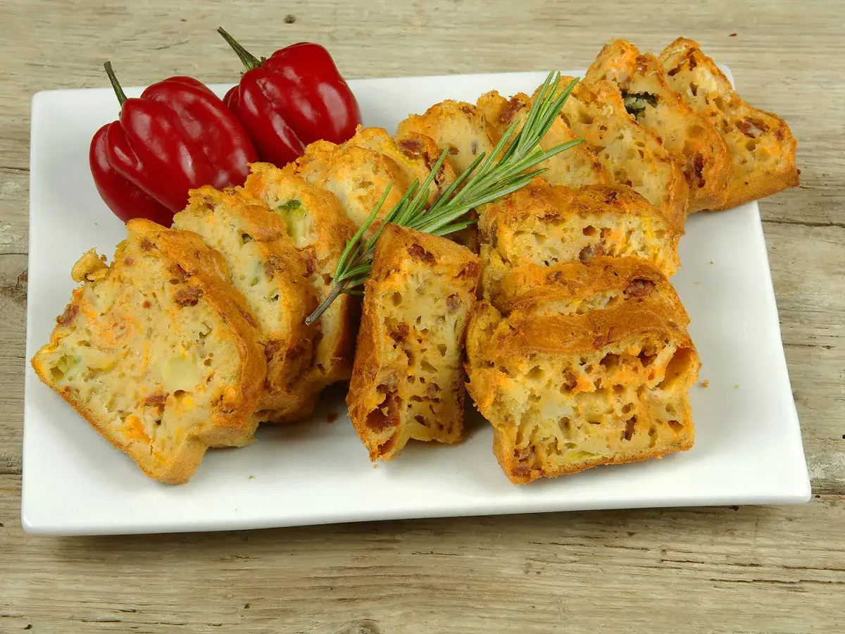 Tranches de cake sal&eacute; au chorizo, garni de poivrons rouges et d'une branche de romarin.
