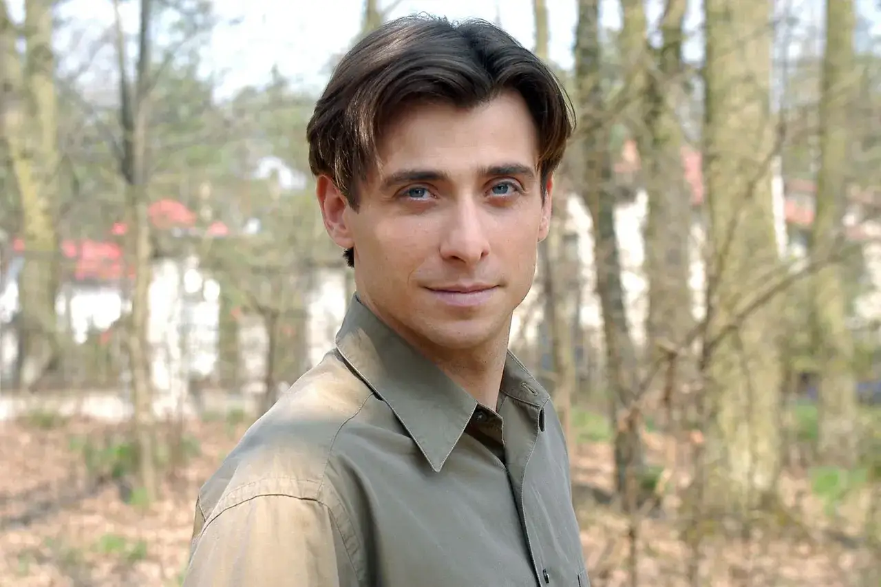 Kacper Kuszewski z błękitnymi oczami i uśmiechem, w koszuli. Czy ma żonę? To pytanie nurtuje fanów.