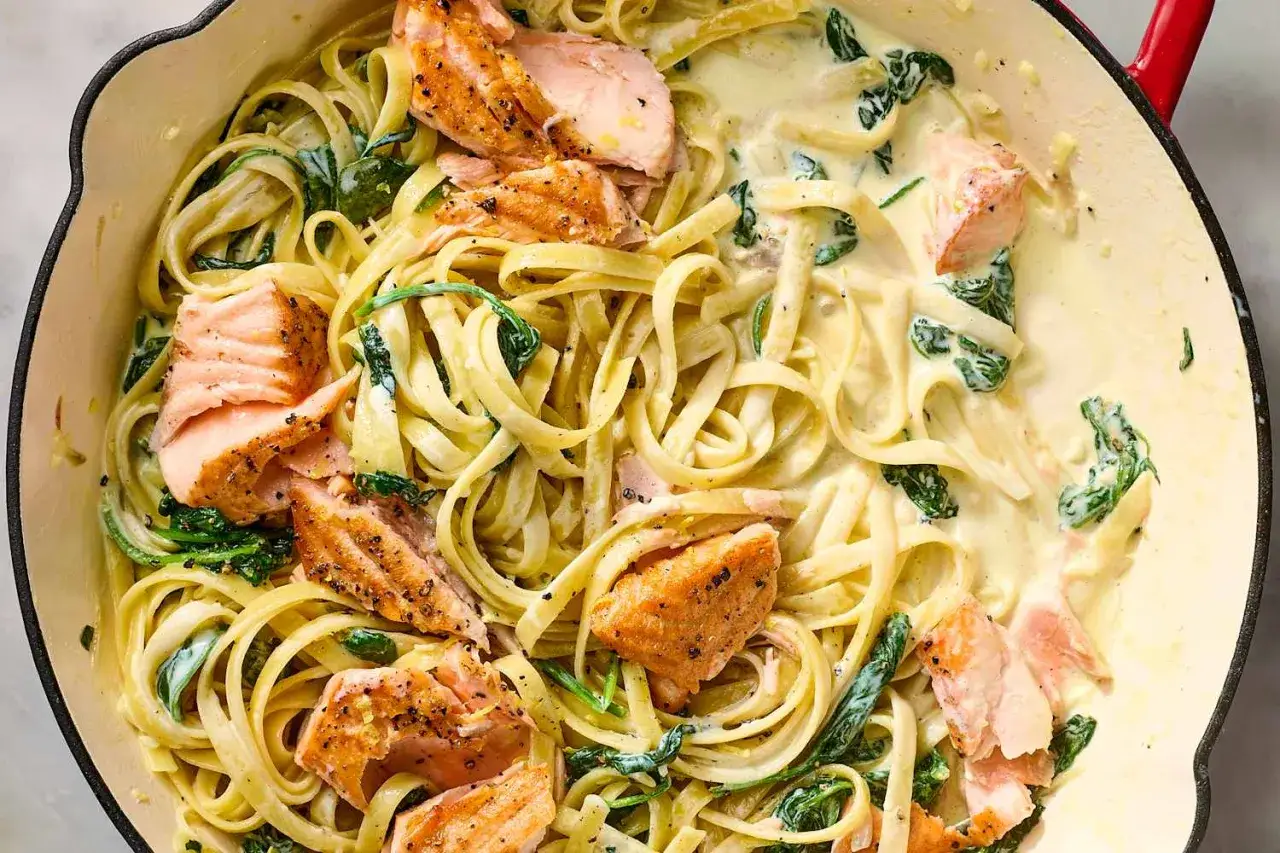 Cremige Lachs Spinat Pasta mit Tagliatelle, garniert mit zarten Lachsst&uuml;cken und frischem Spinat.