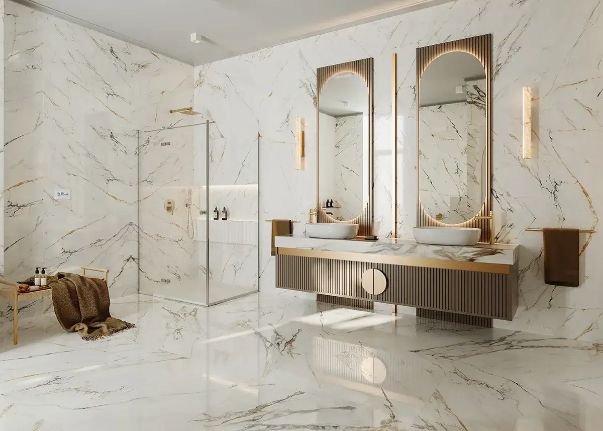 Elegancka łazienka glamour z marmurowymi płytkami, złotymi detalami, podwójną umywalką i prysznicem.