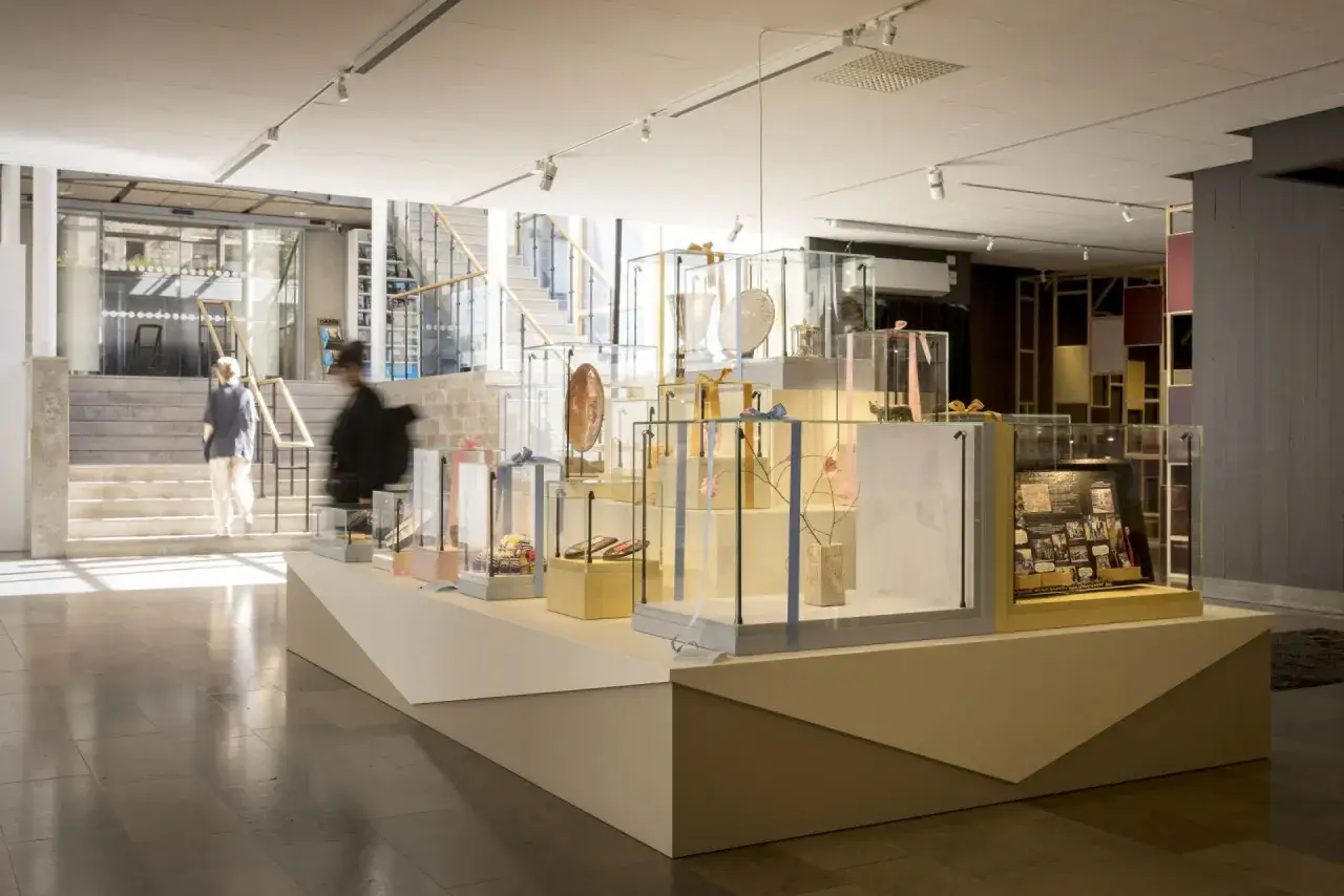 Utställning med föremål i montrar på ett museum i Göteborg. Besökare går i bakgrunden.