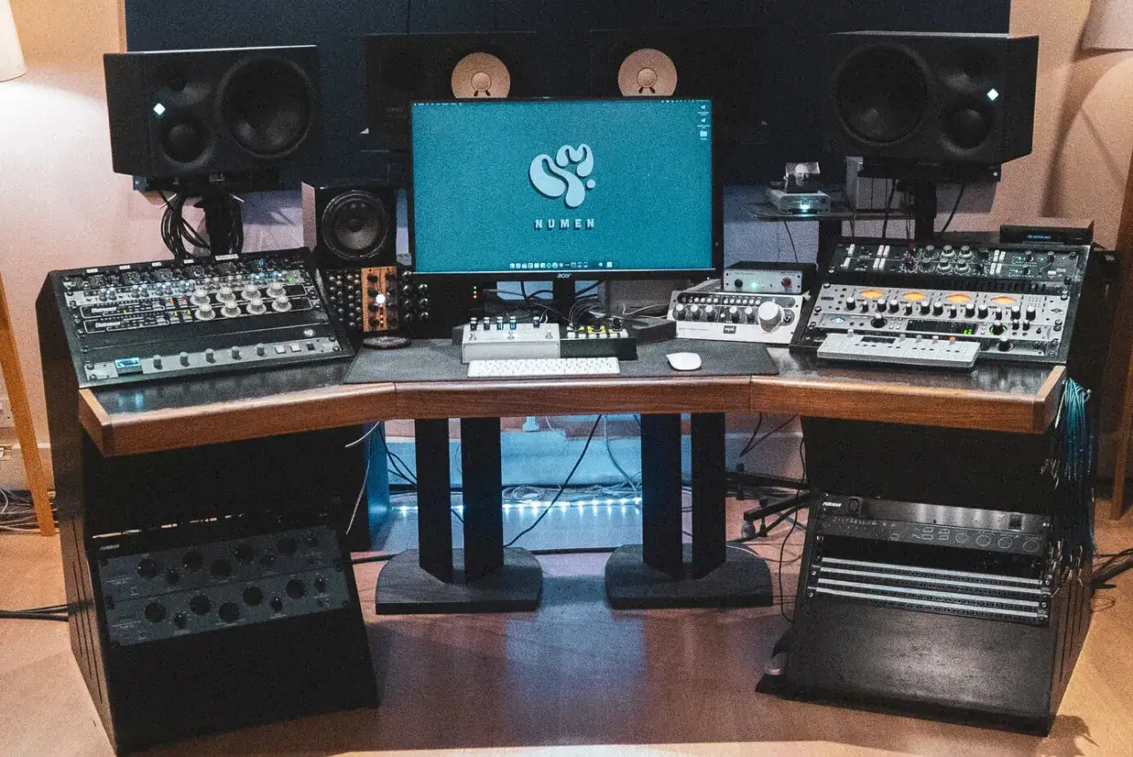 Studio, gotowe do nagraj dźwięk. Komputer, monitory studyjne i sprzęt audio tworzą centrum dowodzenia.