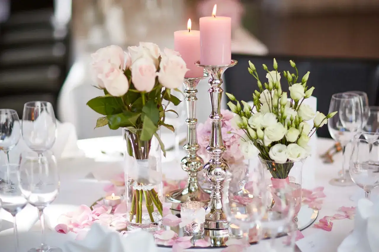 Moderne tischdeko mit zarten Rosen, Kerzen und eleganten Gläsern. Ein romantischer Blickfang.