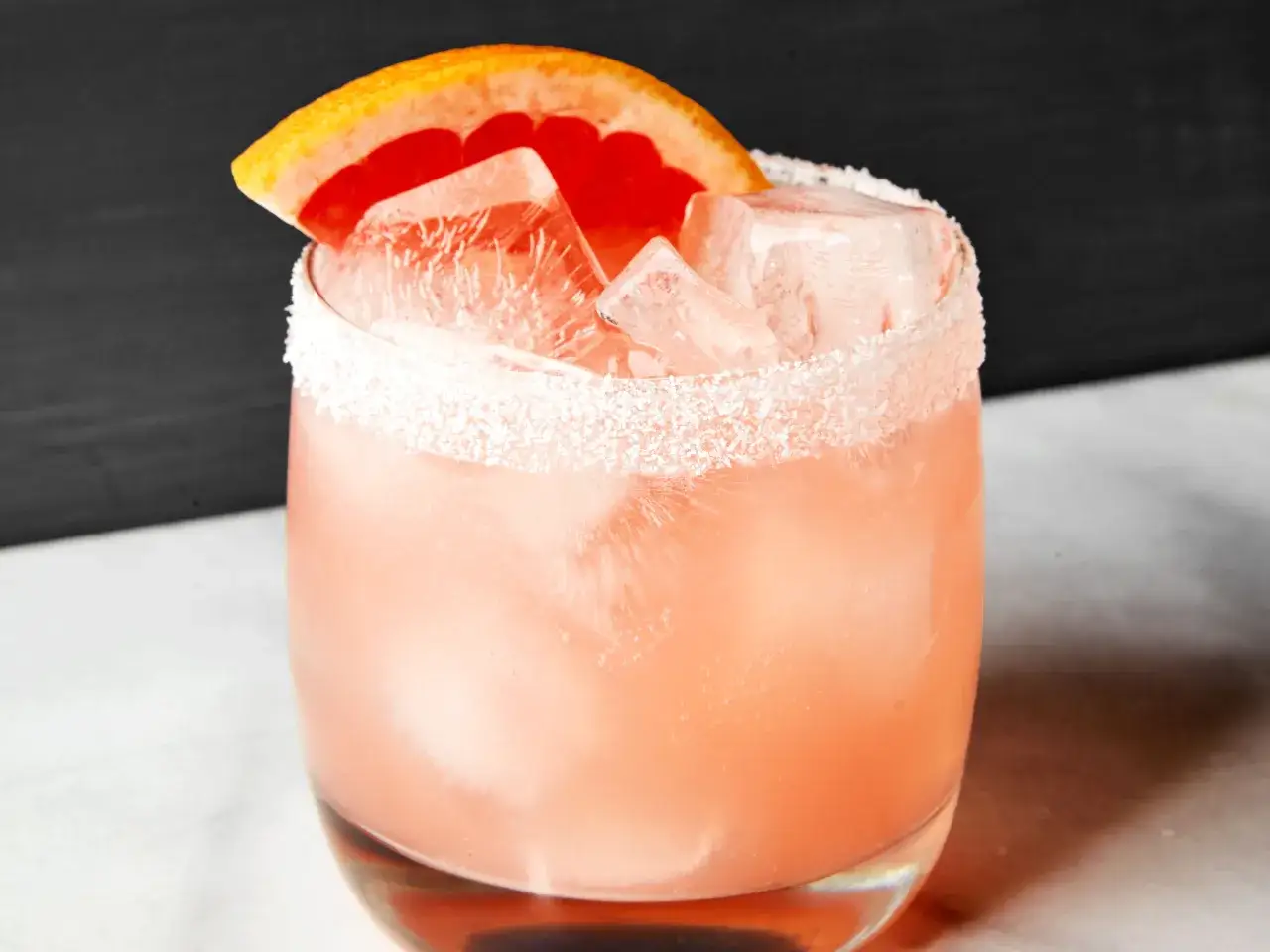 Erfrischender Salty Dog Cocktail mit Eis, Grapefruit-Garnitur und salzigem Glasrand.
