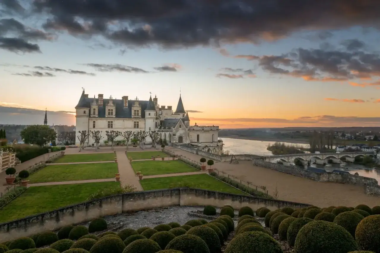 Le château d'Amboise se dresse majestueusement au-dessus de la Loire, baigné par la lumière dorée du crépuscule. Ses jardins soignés invitent à la promenade.