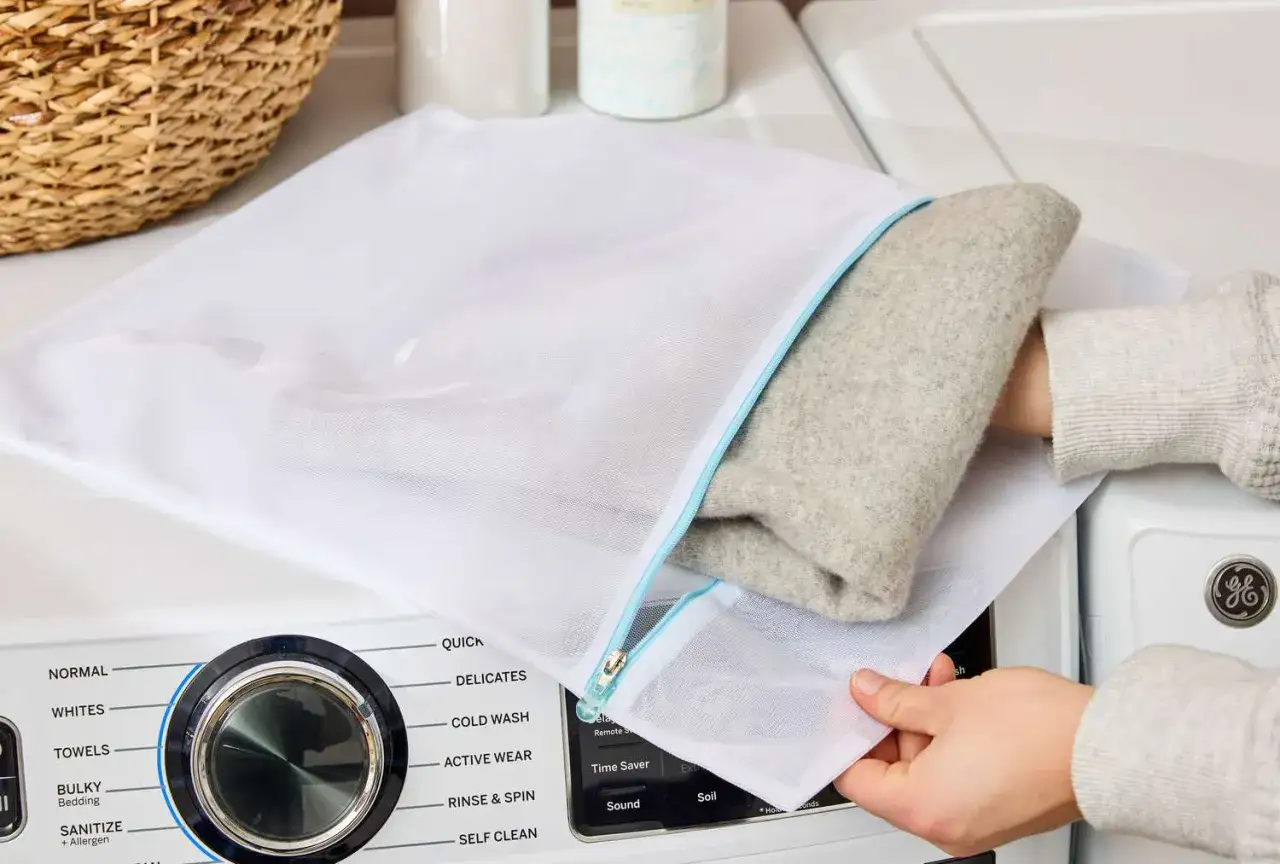 Ein Pullover aus Kaschmir wird zum Kaschmir waschen in einen Wäschebeutel gelegt.