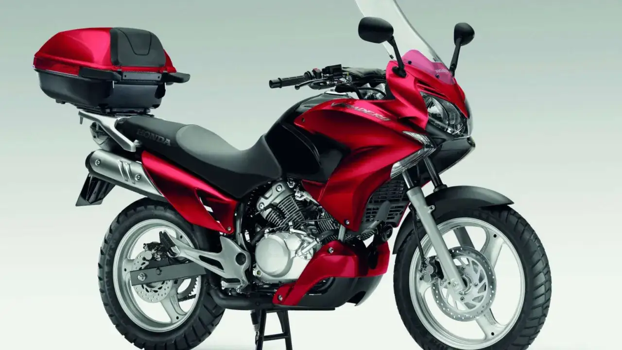 Czerwony motocykl Honda Varadero 125 z kufrem. Poznaj honda varadero 125 dane techniczne i możliwości tego wszechstronnego jednośladu.
