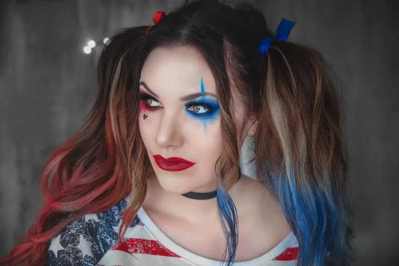 Sista minuten halloween sminkning inspirerad av Harley Quinn med r&ouml;tt och bl&aring;tt smink, hj&auml;rtformad tatuering och tv&aring; tofsar.