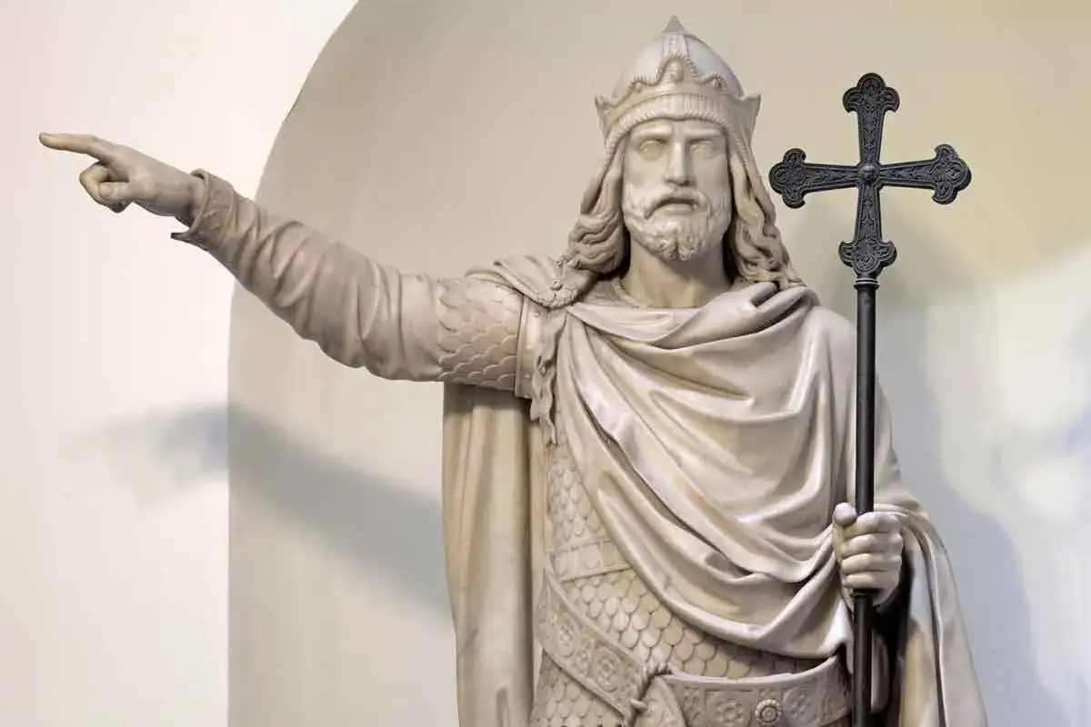 Estatua de mármol de Don Pelayo, líder de la Reconquista, señalando el camino con una cruz.