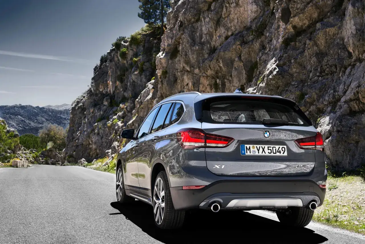 Szary BMW X1 na górskiej drodze. Sprawdź aktualną bmw x1 cena i wybierz się na przygodę!