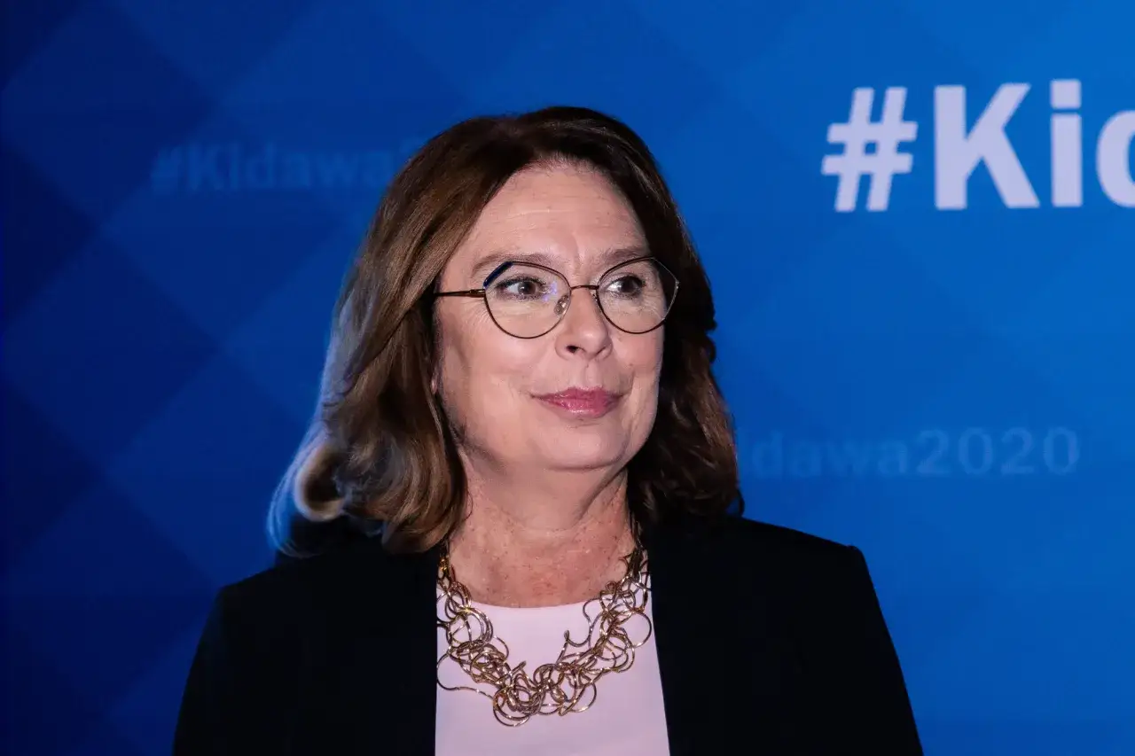 Kobieta w okularach, z naszyjnikiem, na tle z napisem #Kidawa2020. Ile lat ma Kidawa Błońska?