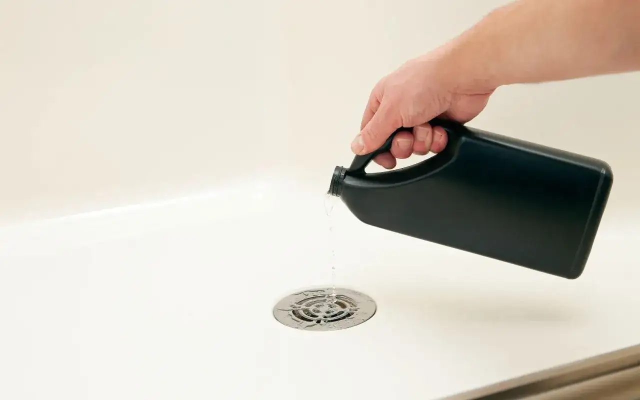 Main versée dans la douche pour déboucher le siphon.
