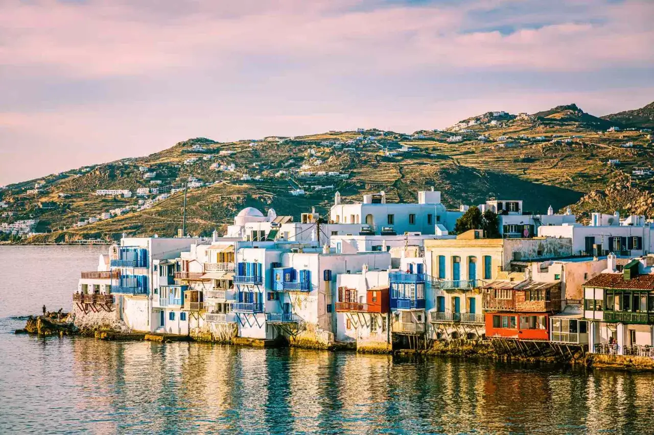 Les plus belles &icirc;les grecques : maisons blanches et bleues au bord de l'eau, collines verdoyantes.