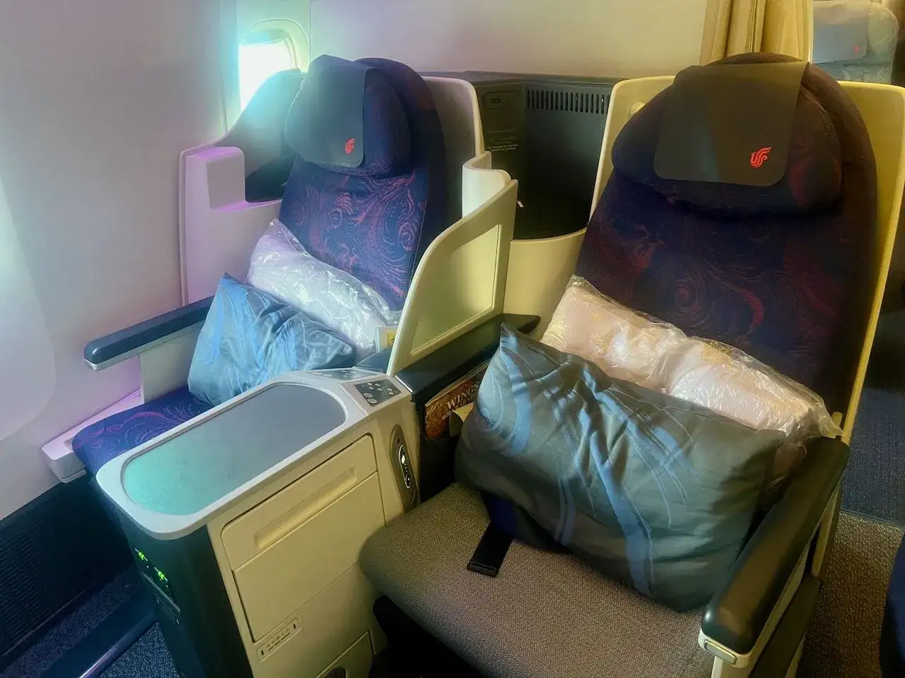 Fotele klasy biznes Air China, wygodne i przestronne, z poduszkami i kocami. Dobre air china opinie.