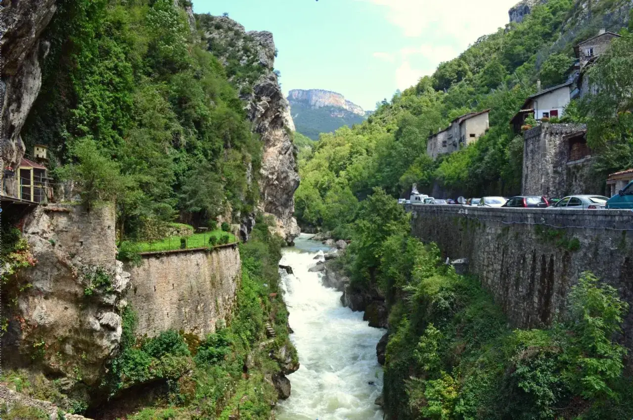 Magnifique vue d'un pont en Royans, idéal pour une randonnée. La rivière tumultueuse serpente entre des falaises verdoyantes.