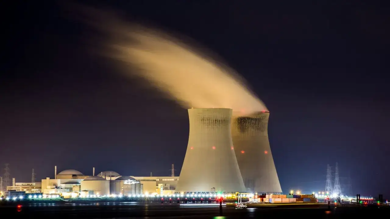 Dwie chłodnie kominowe elektrowni atomowej nocą, z których wydobywa się para. Niemcy obecnie nie posiadają czynnych elektrowni atomowych.