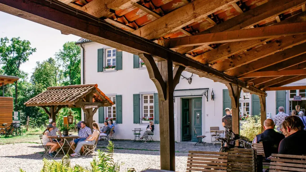 G&auml;ste genie&szlig;en die Sonne auf dem Hohkeppeler Hof. Ein idyllischer Ort mit traditionellem Gasthaus und gem&uuml;tlicher Au&szlig;ensitzgelegenheit.