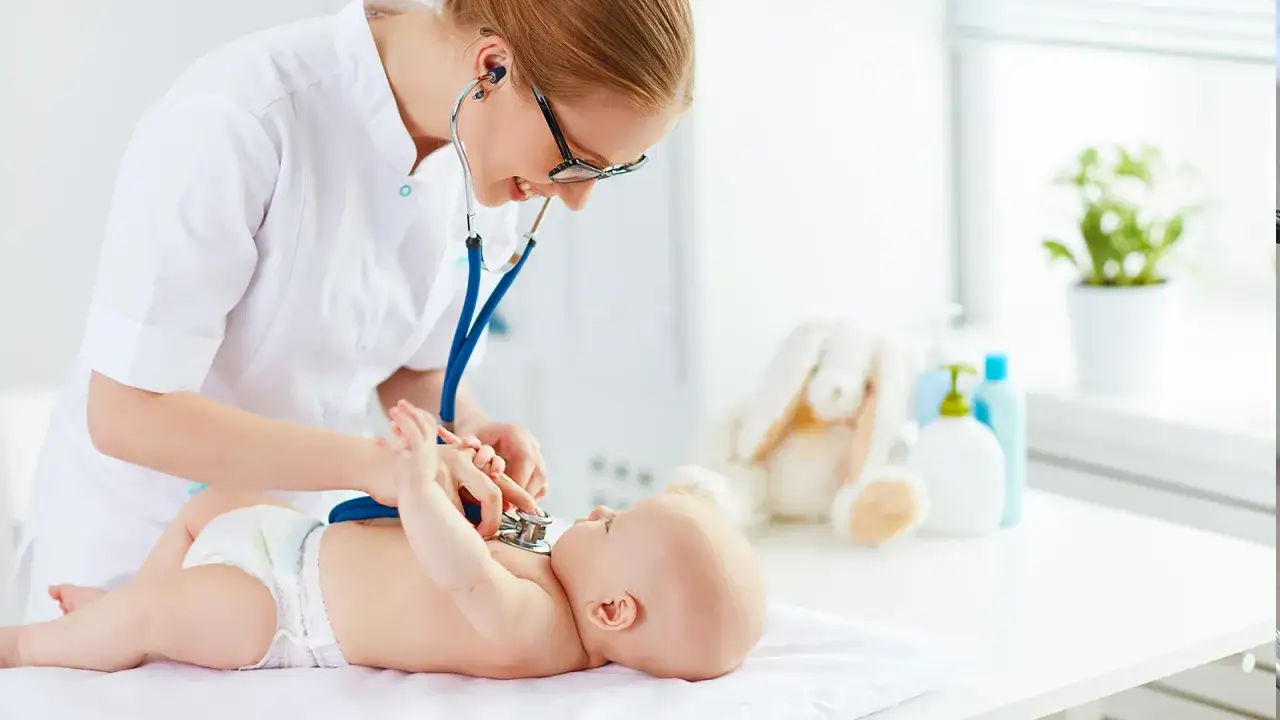 Pediatra visita un neonato con lo stetoscopio. Chissà quanto guadagna una pediatra al mese per prendersi cura dei più piccoli.