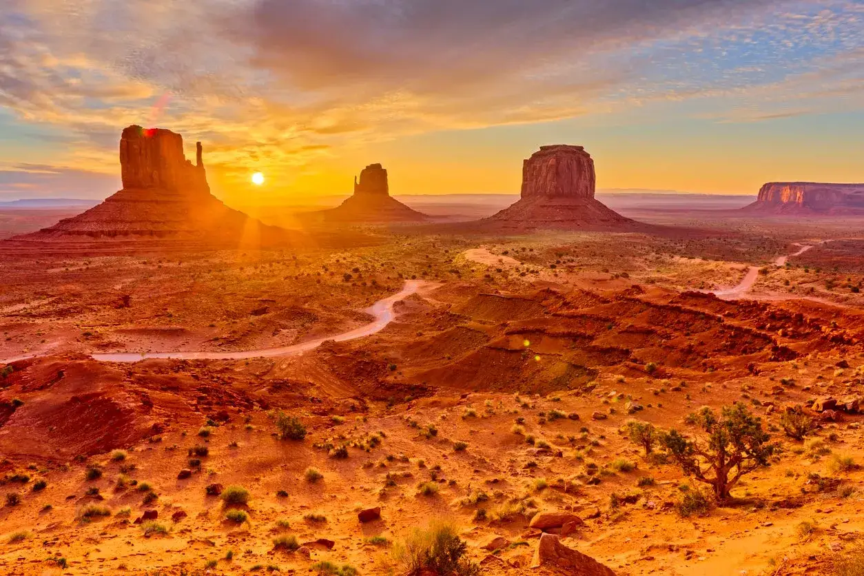 Monument Valley o zachodzie słońca, idealne miejsce na wycieczki do USA. Czerwone skały i pustynny krajobraz.