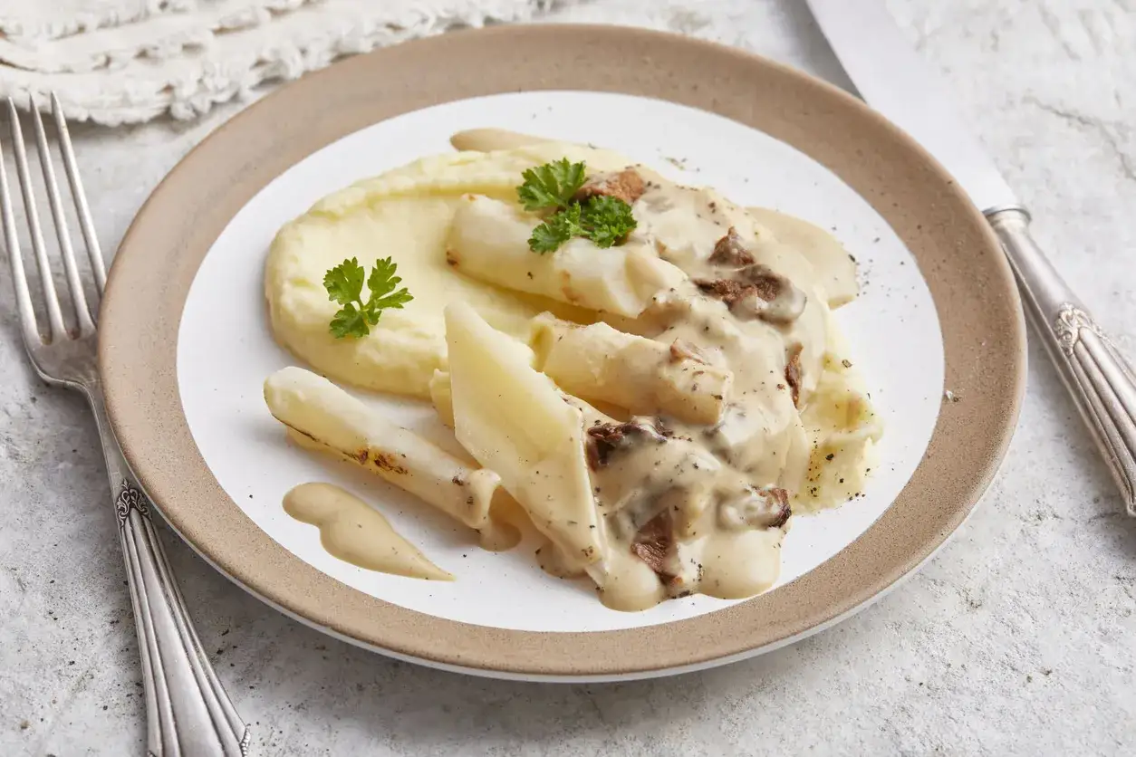 Schwarzwurzeln mit cremiger Sauce und Kartoffelpüree. Ein köstliches Schwarzwurzeln Rezept, garniert mit Petersilie.