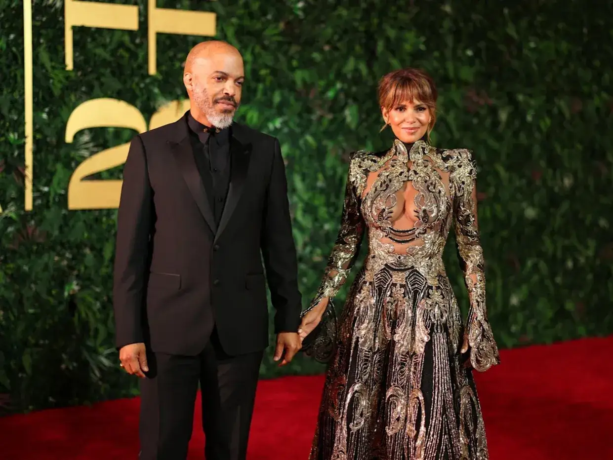 Halle Berry i jej mąż, Van Hunt, na czerwonym dywanie. Ona w olśniewającej, złotej sukni, on w eleganckim czarnym garniturze.