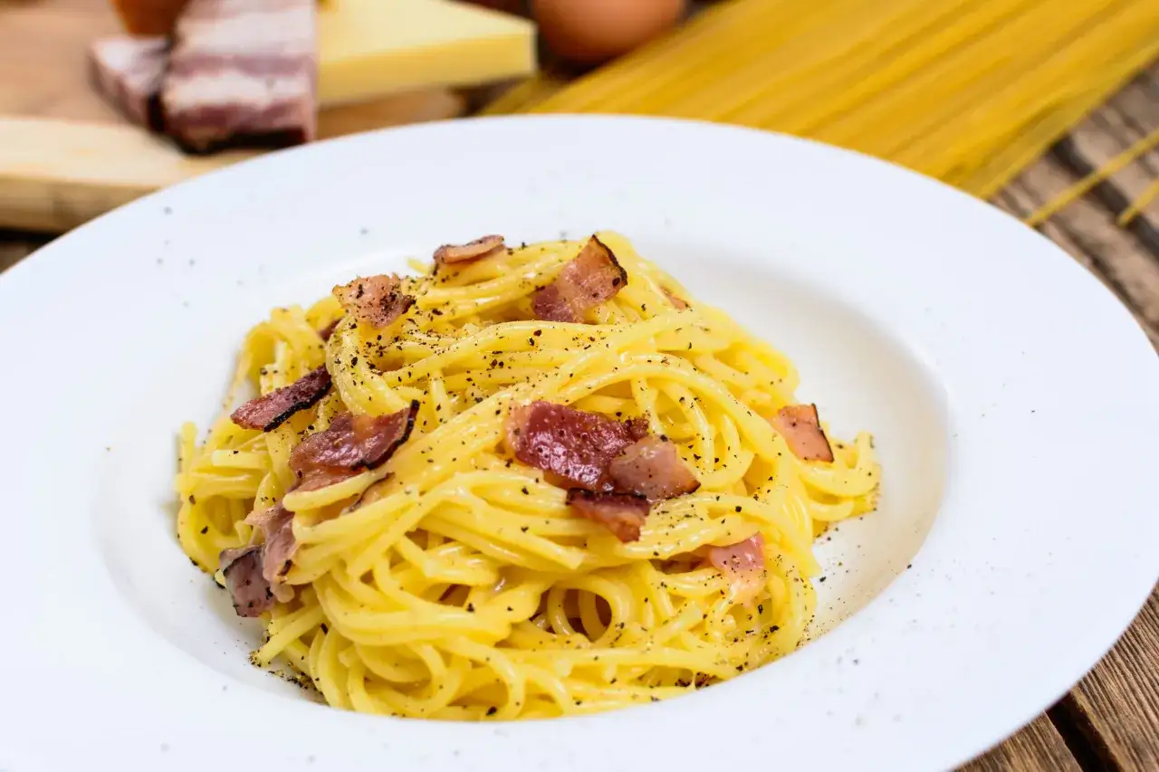 Un piatto di spaghetti alla carbonara, con guanciale croccante e pepe nero. La ricetta perfetta per un pranzo veloce e gustoso.