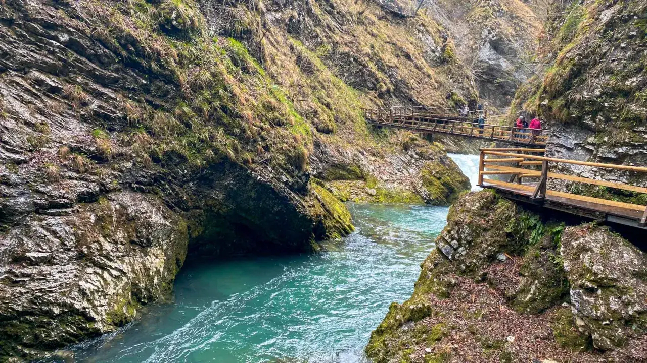 T&uuml;rkisblaue Wasserf&auml;lle und Holzstege im Bleder See Canyon. Wanderer genie&szlig;en die beeindruckende Natur.