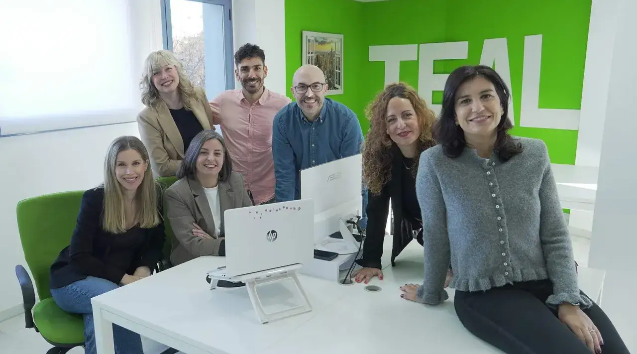 Equipo de consultores de RRHH sonr&iacute;e en una oficina moderna.