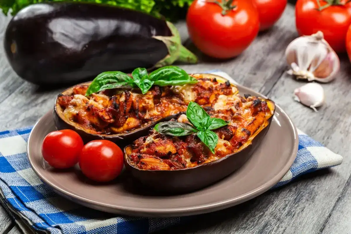 Melanzane ripiene vegetariane, gustoso piatto con pomodori, basilico e formaggio fuso.
