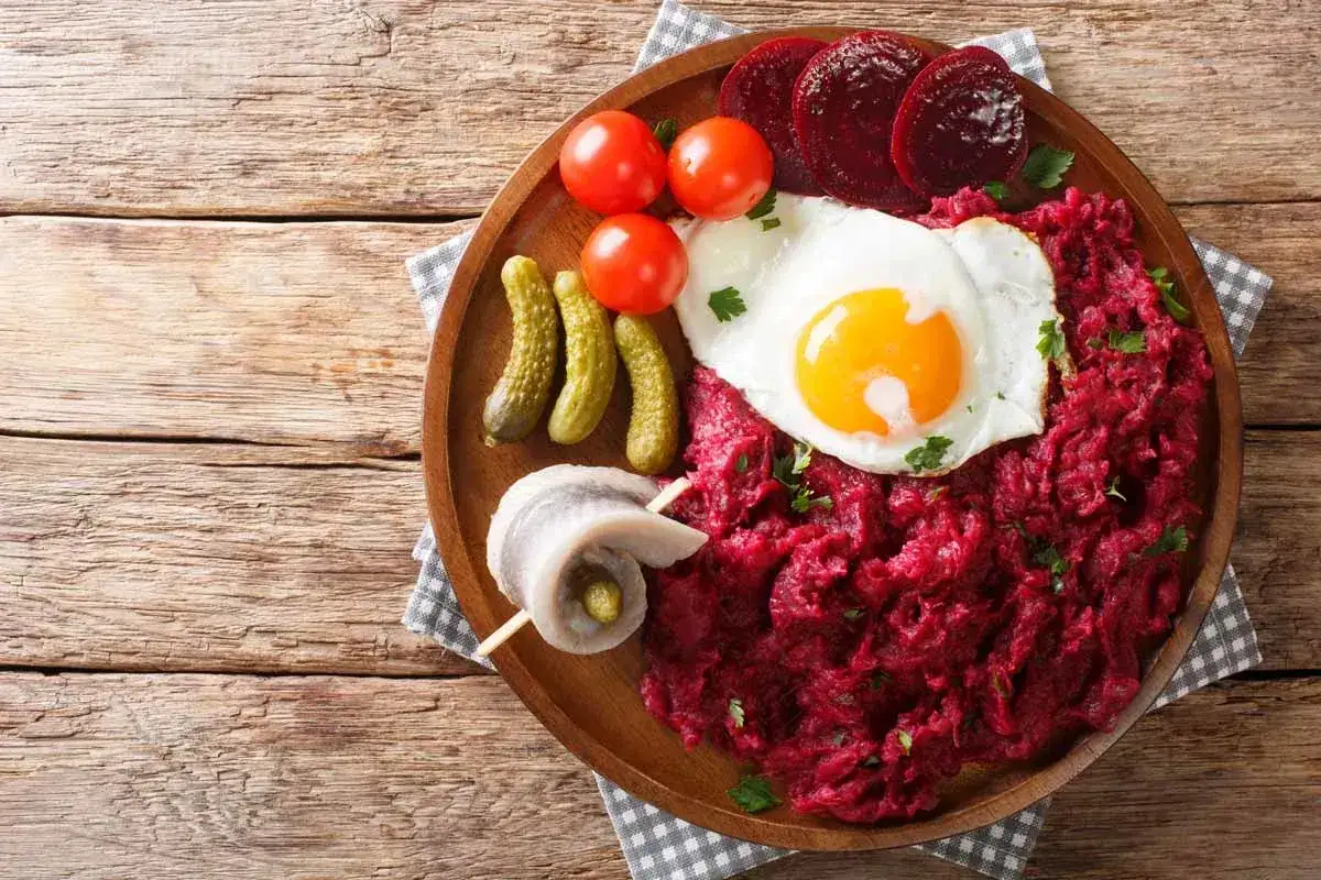 Labskaus: ein herzhaftes Gericht mit Roter Bete, Kartoffeln, Cornichons, Matjes und Spiegelei.