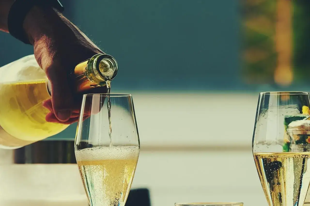 Sekt wird in ein Glas gegossen. Die Haltbarkeit des Sekts abzulesen ist hier nicht m&ouml;glich, aber das Sprudeln verspricht Genuss.
