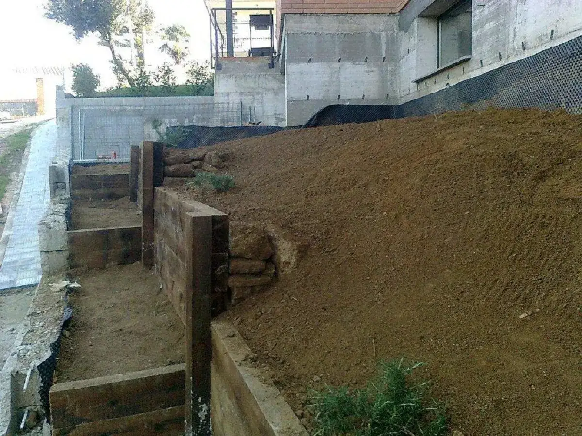 Costruzione di terrazzamenti con travi di legno per livellare pavimento in pendenza.