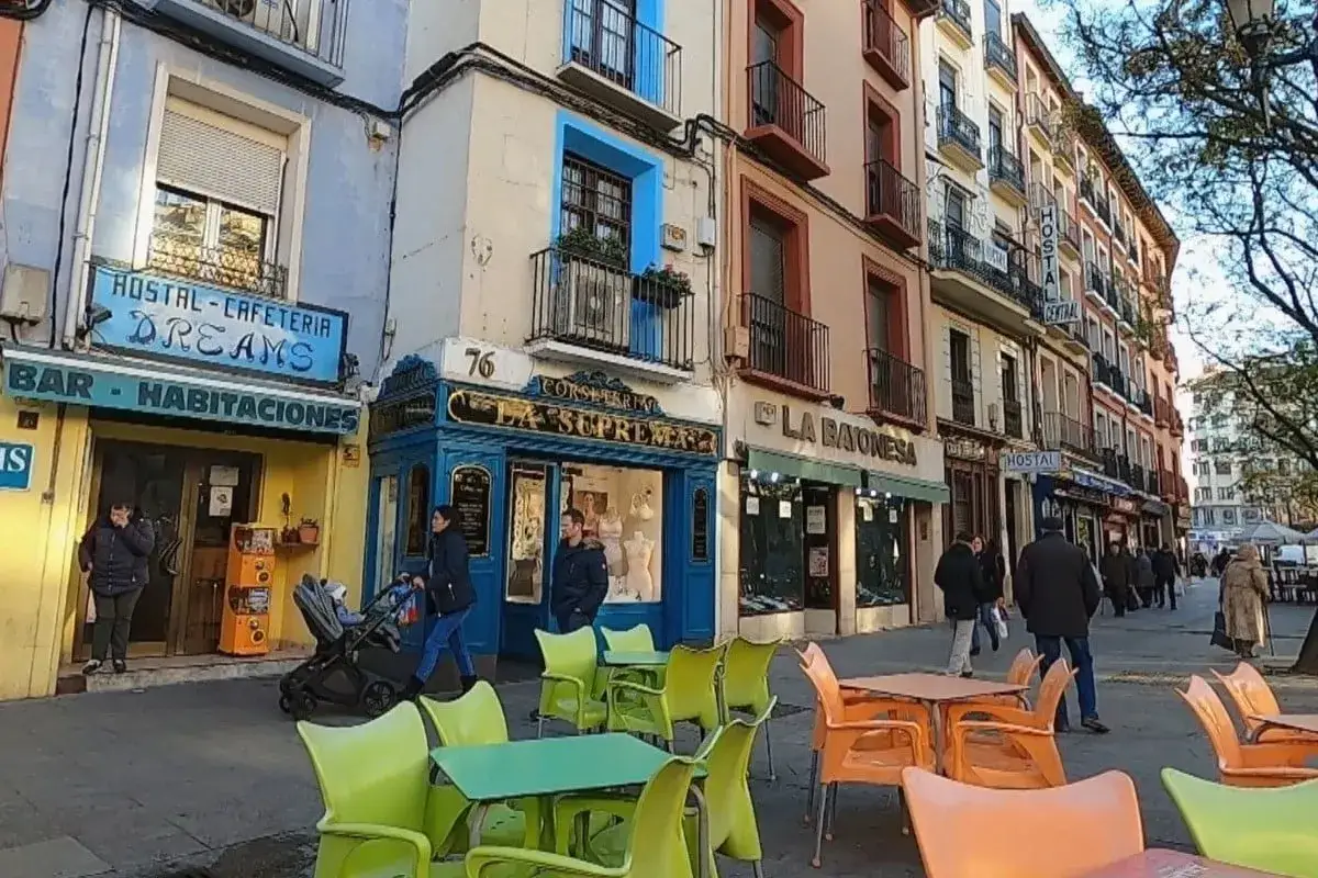 Calle con hostales y tiendas, un ejemplo de competencia monopolística donde cada negocio ofrece algo único.