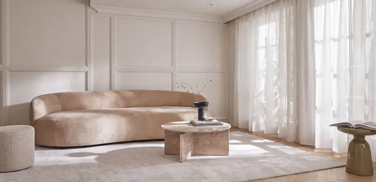 Elegancki salon w odcieniach beżu i **kolor ecru jaki to kolor** – miękka sofa, okrągły stolik i jasne zasłony tworzą przytulną atmosferę.