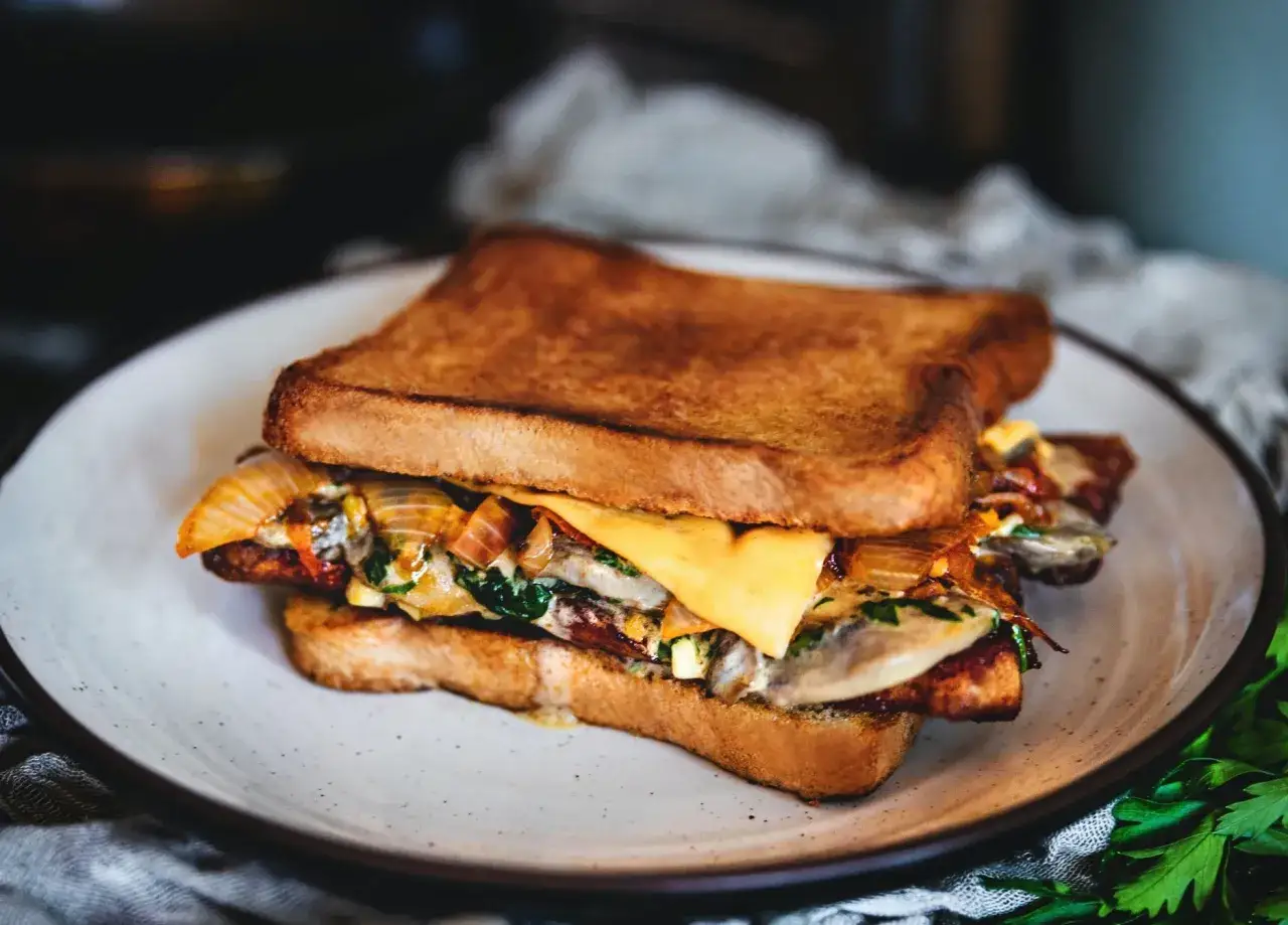 Pyszny tost z serem, cebulką i szpinakiem. Zastanawiasz się, ile kcal ma tost z serem? Ten wygląda na sycący!