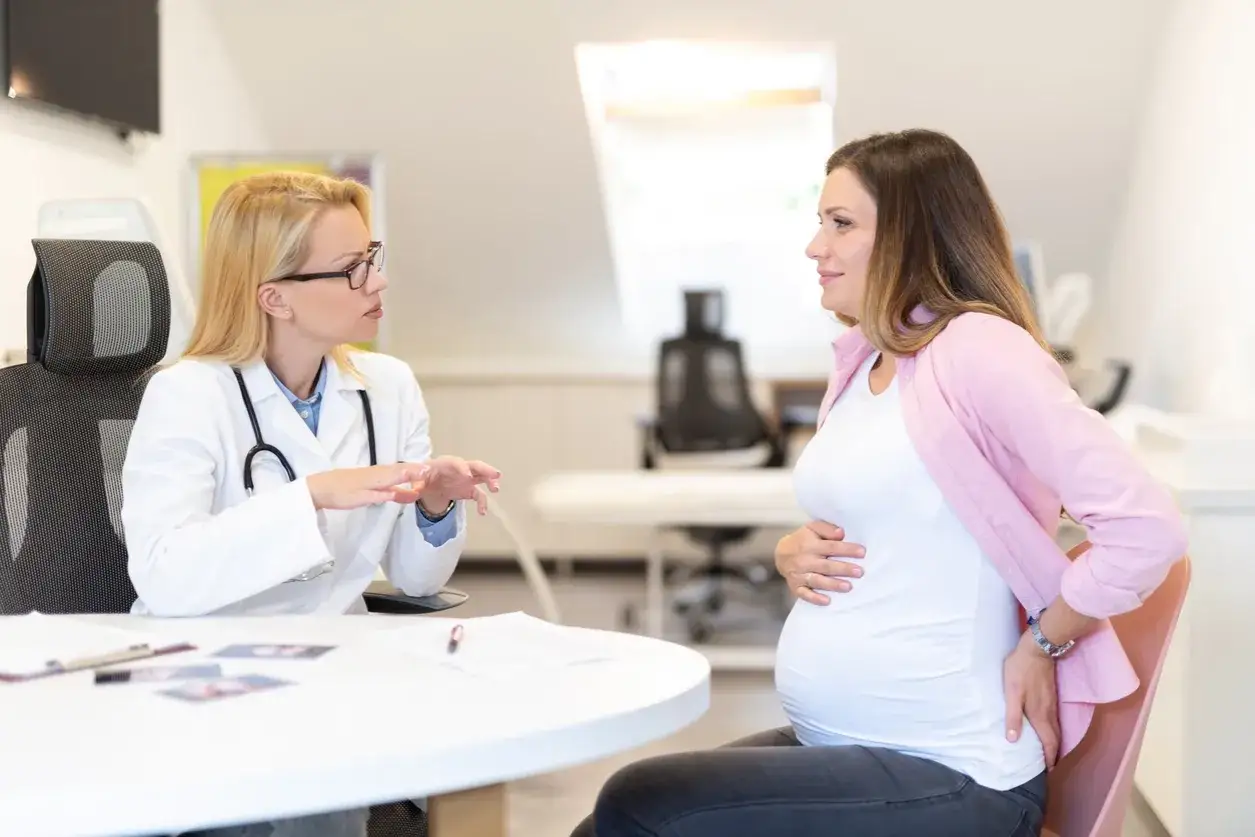 L&auml;kare diskuterar med gravid kvinna om ilningar i underlivet.